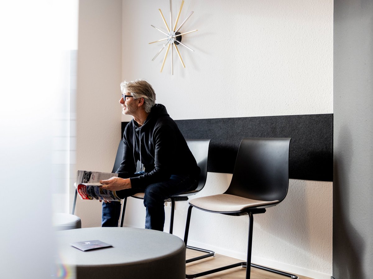 Ein Patient sitzt in einem modernen Wartezimmer